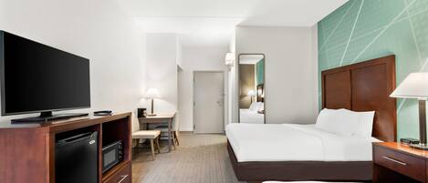A hotel room with a bed, a desk, a television, and a wardrobe.