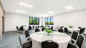 A conference room with round tables, chairs, and large windows. - Comfort Inn Pocono Lakes Region (Lake Ariel)