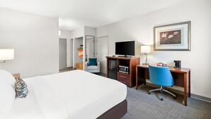 A hotel room with a bed, a desk with a computer, a chair, a television, and a framed picture on the wall. - Comfort Inn Pocono Lakes Region (Lake Ariel)