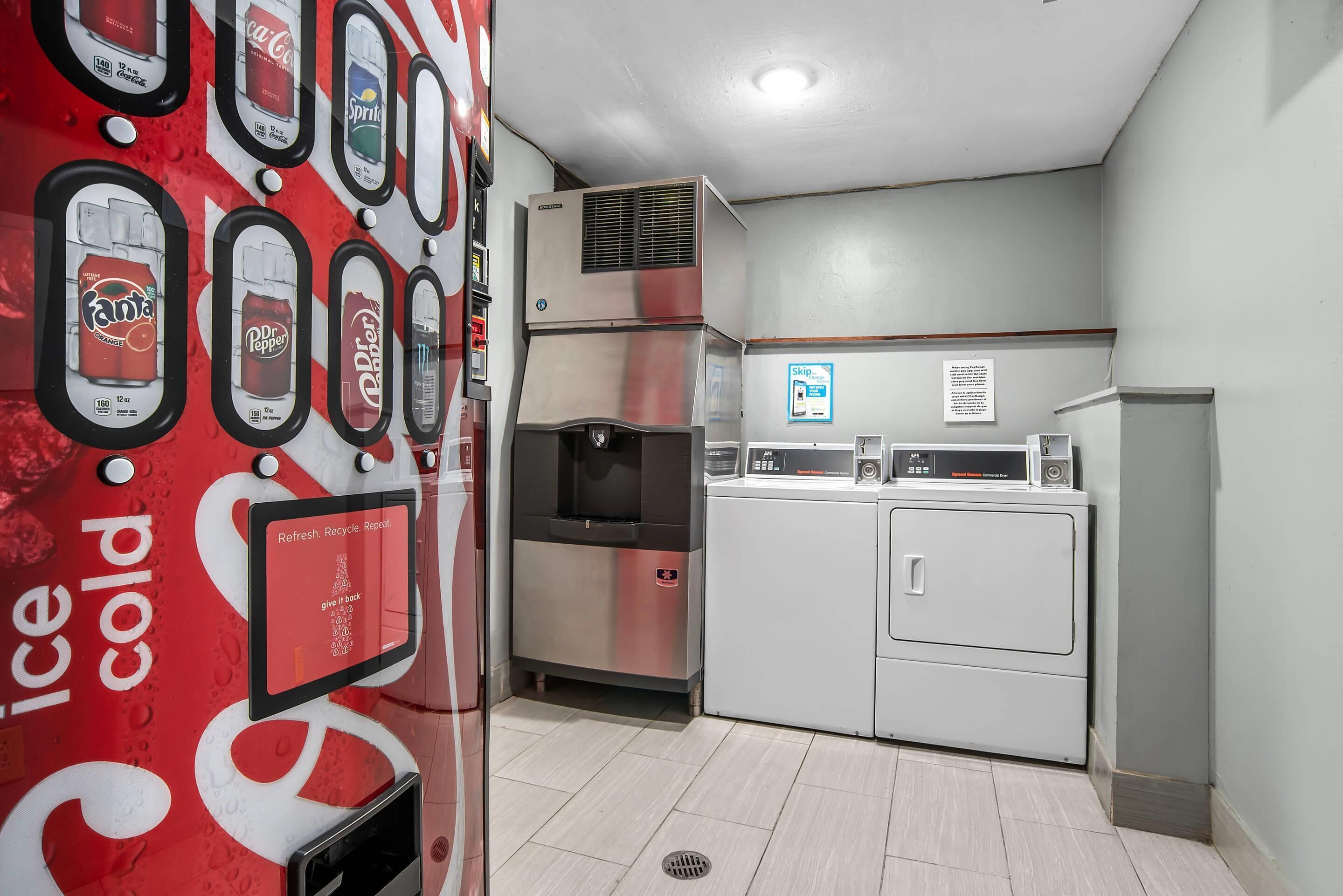 Una cocina compacta con refrigerador, microondas y dispensador de agua.