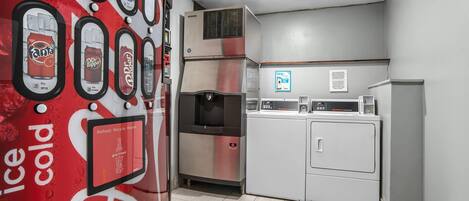 Una cocina compacta con refrigerador, microondas y dispensador de agua.
