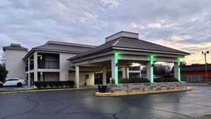 Un hotel con entrada cubierta y aparcamiento.