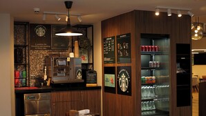 Una cocina moderna con cafetera, refrigerador y un tablero de menú.