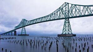 A large suspension bridge with a complex truss structure spanning over water, supported by two large towers. - Shilo Inn Suites Warrenton (Warrenton)