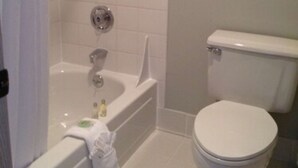 A bathroom with a bathtub, toilet, and a shower curtain. - Shilo Inn Suites Warrenton (Warrenton)