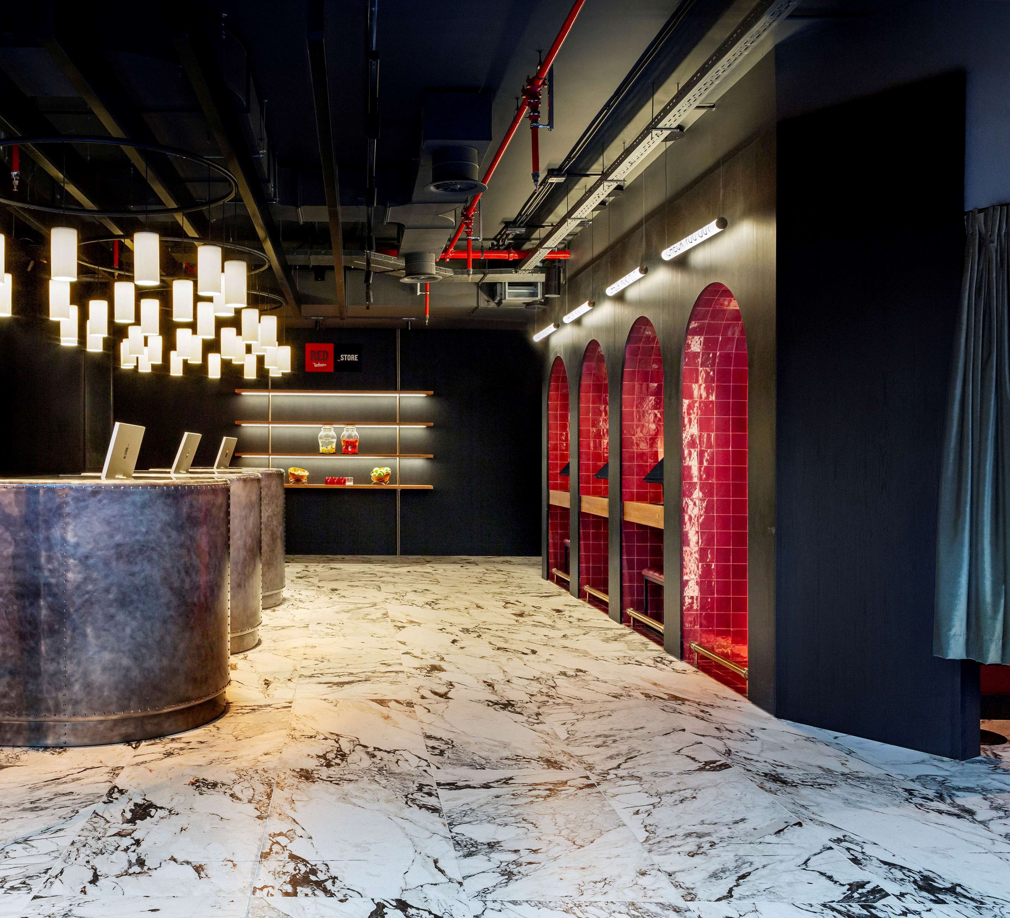 Un interno moderno con pavimento in marmo, una reception e un negozio Red Bull.