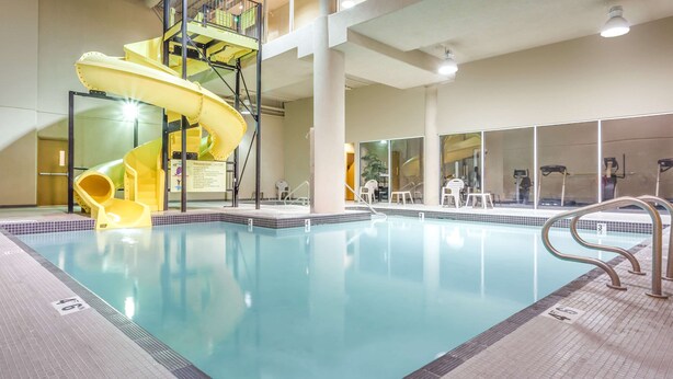 An indoor swimming pool with a yellow slide and a staircase. - Super 8 by Wyndham Abbotsford BC (Abbotsford)