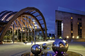 A modern building with a large glass facade and a distinctive arched entrance.