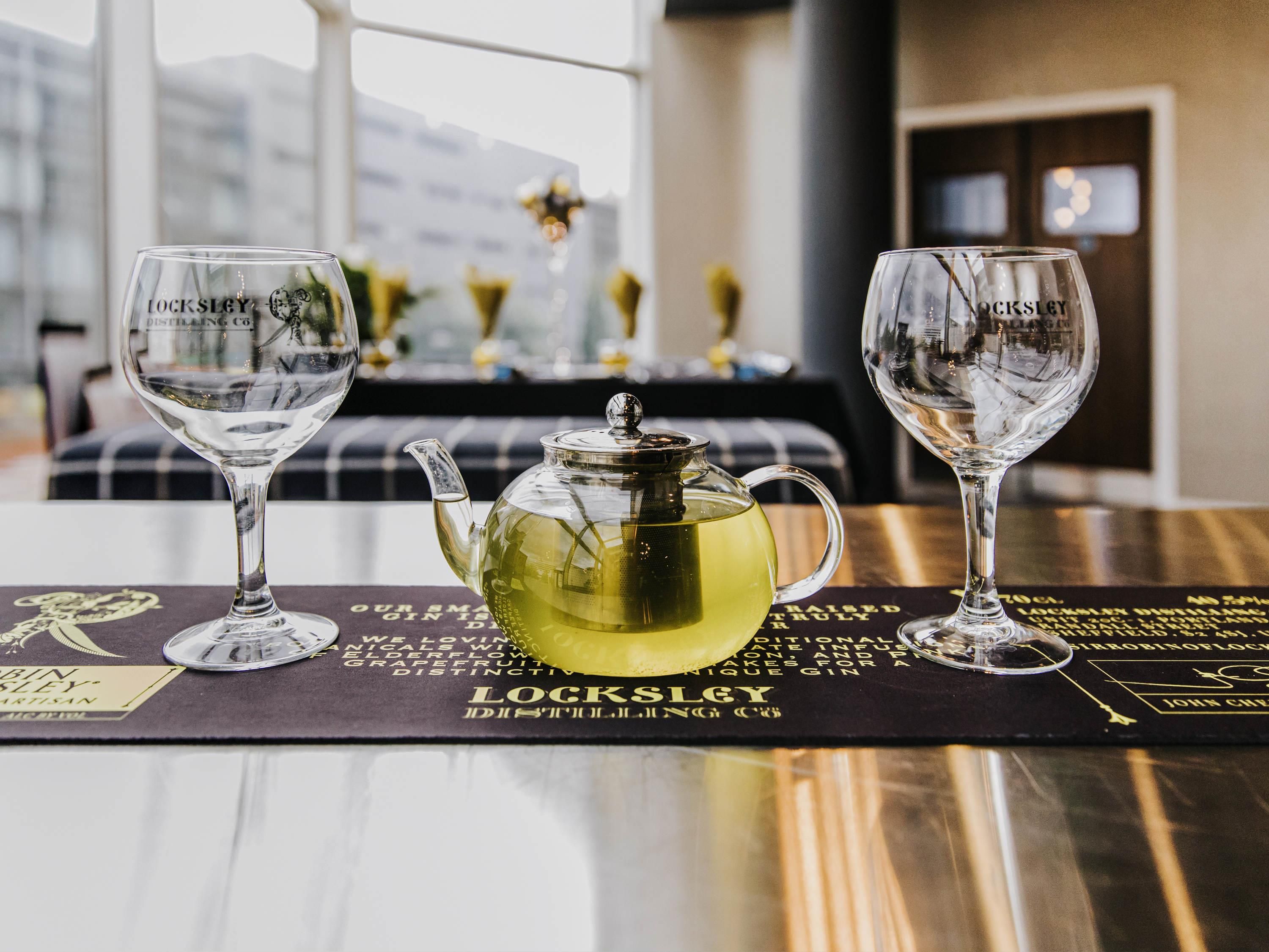A table with two Lockley glasses, a teapot, and a menu.