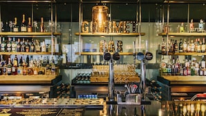 A bar with shelves of liquor bottles, a bar counter with taps, and a sign reading "GOLD BAR". - Novotel Sheffield Centre (Sheffield)
