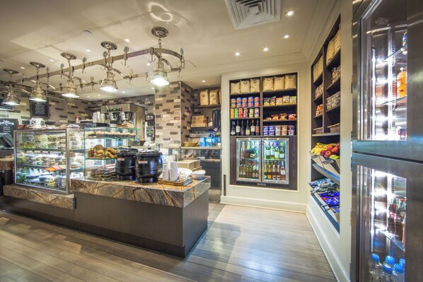 A bakery counter with pastries, a coffee machine, and a refrigerated display with beverages.