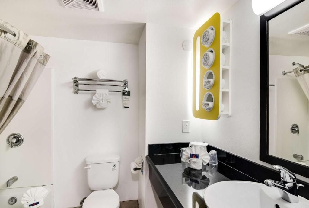 A bathroom with a toilet, sink, and towel rack.