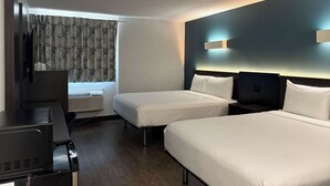 A hotel room with two beds, a desk, and a window with patterned curtains. - Motel 6 Carson, CA (Carson)