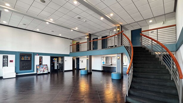 A spacious lobby with a staircase, a vending machine, and a reception desk. - Motel 6 Carson, CA (Carson)
