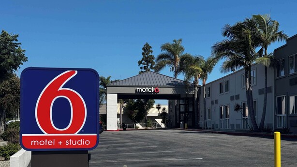 A motel sign with a large '6' and 'motel + studio' text, indicating the establishment's name and type.