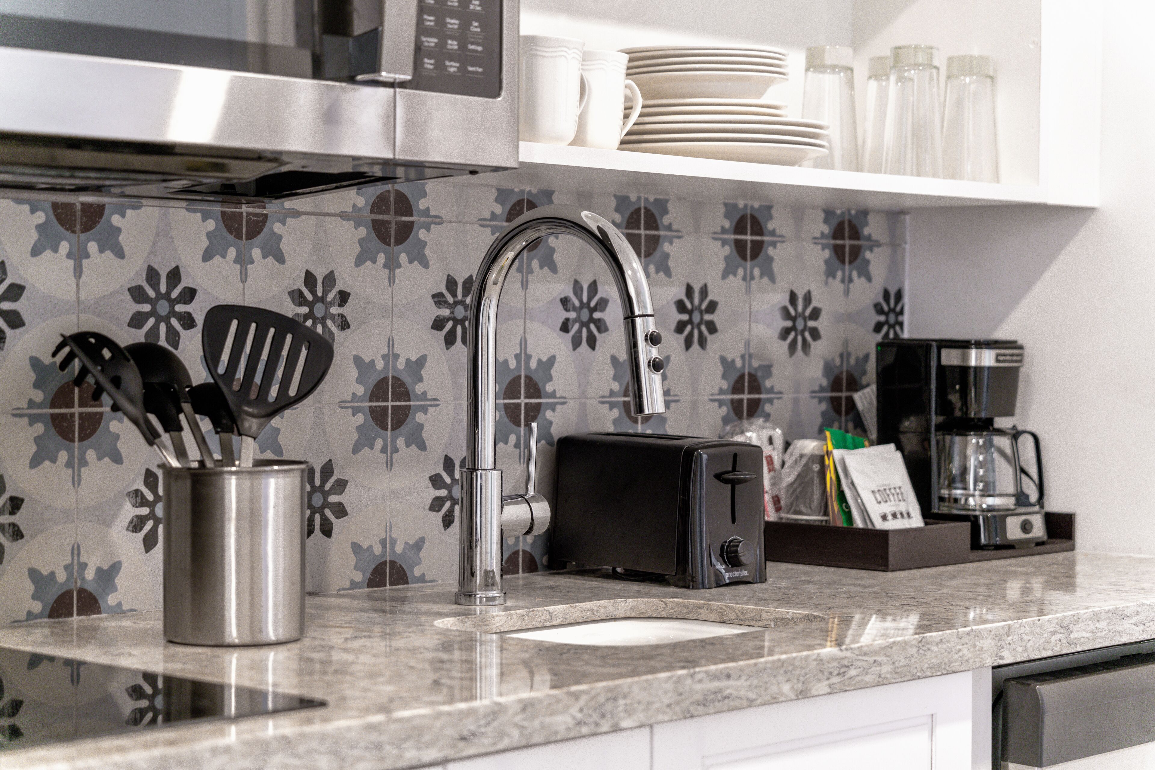 Een keuken met een roestvrijstalen spoelbak, een broodrooster en een koffiezetapparaat.