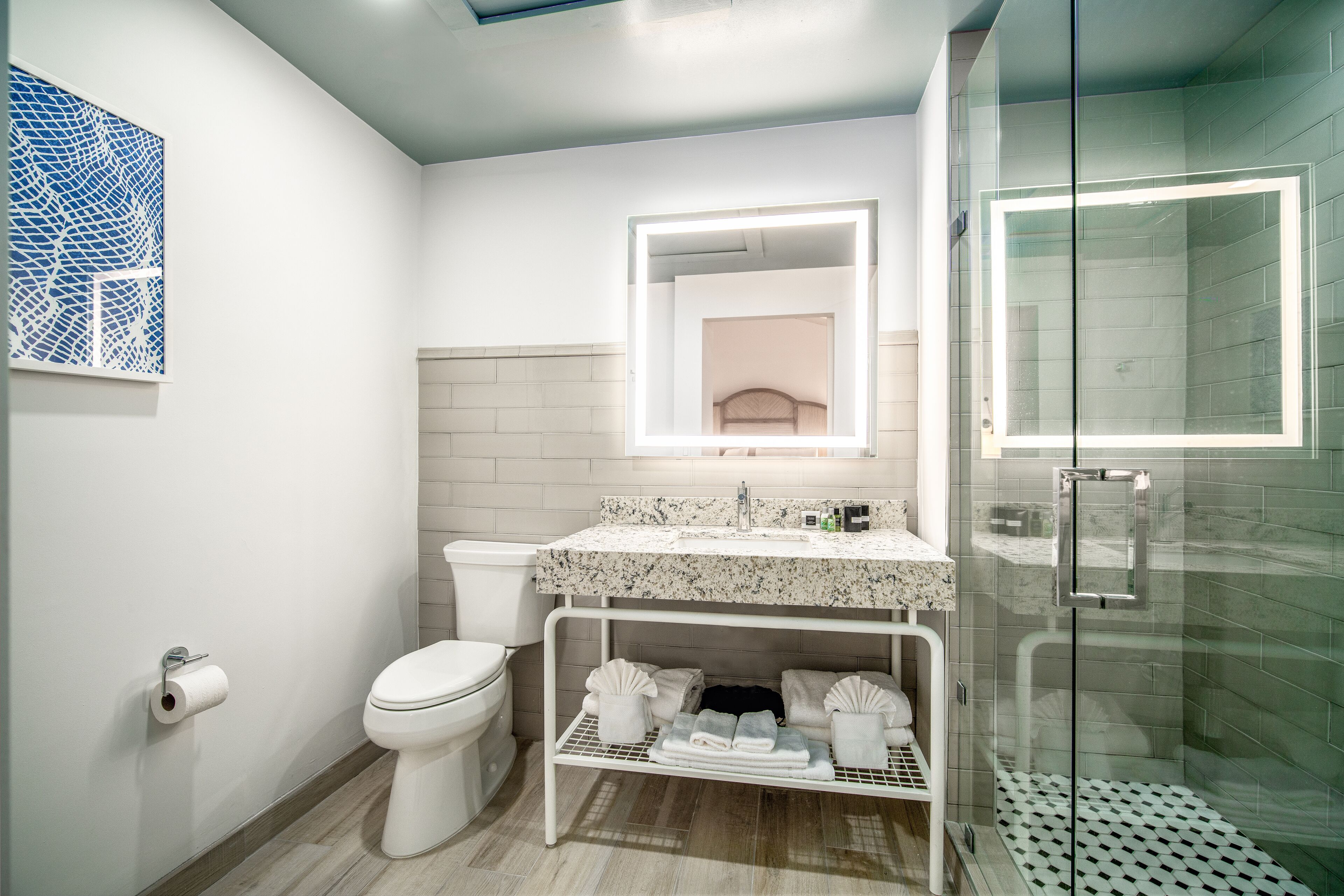 Et moderne badeværelse med toilet, håndvask og bruser.