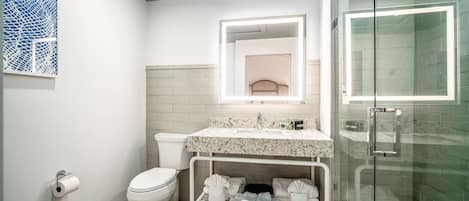 A modern bathroom with a toilet, sink, and shower.