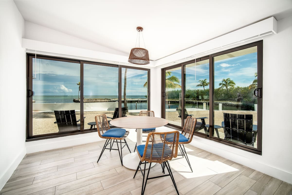 A spacious room with large windows offering a view of the beach and ocean.