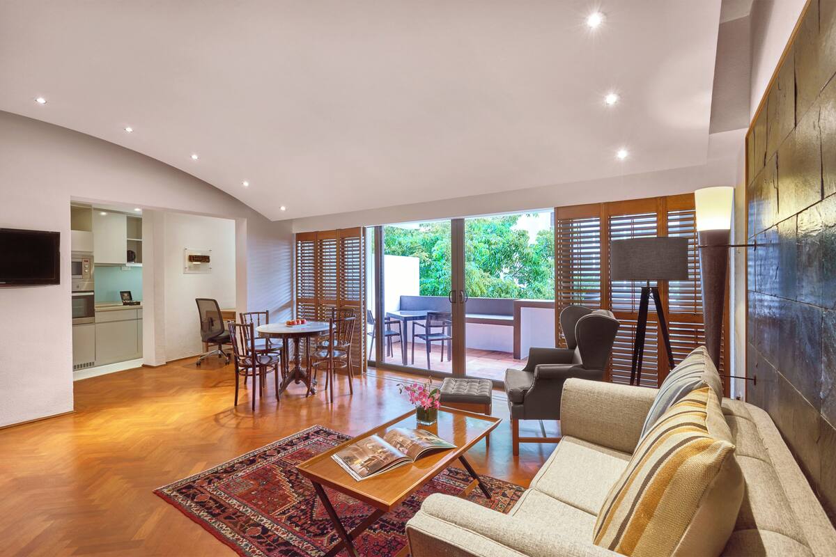 Una sala de estar moderna con sofá, mesa de centro y comedor.