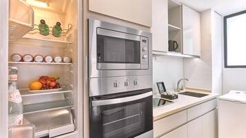 A modern kitchen with a built-in oven, microwave, and a sink.