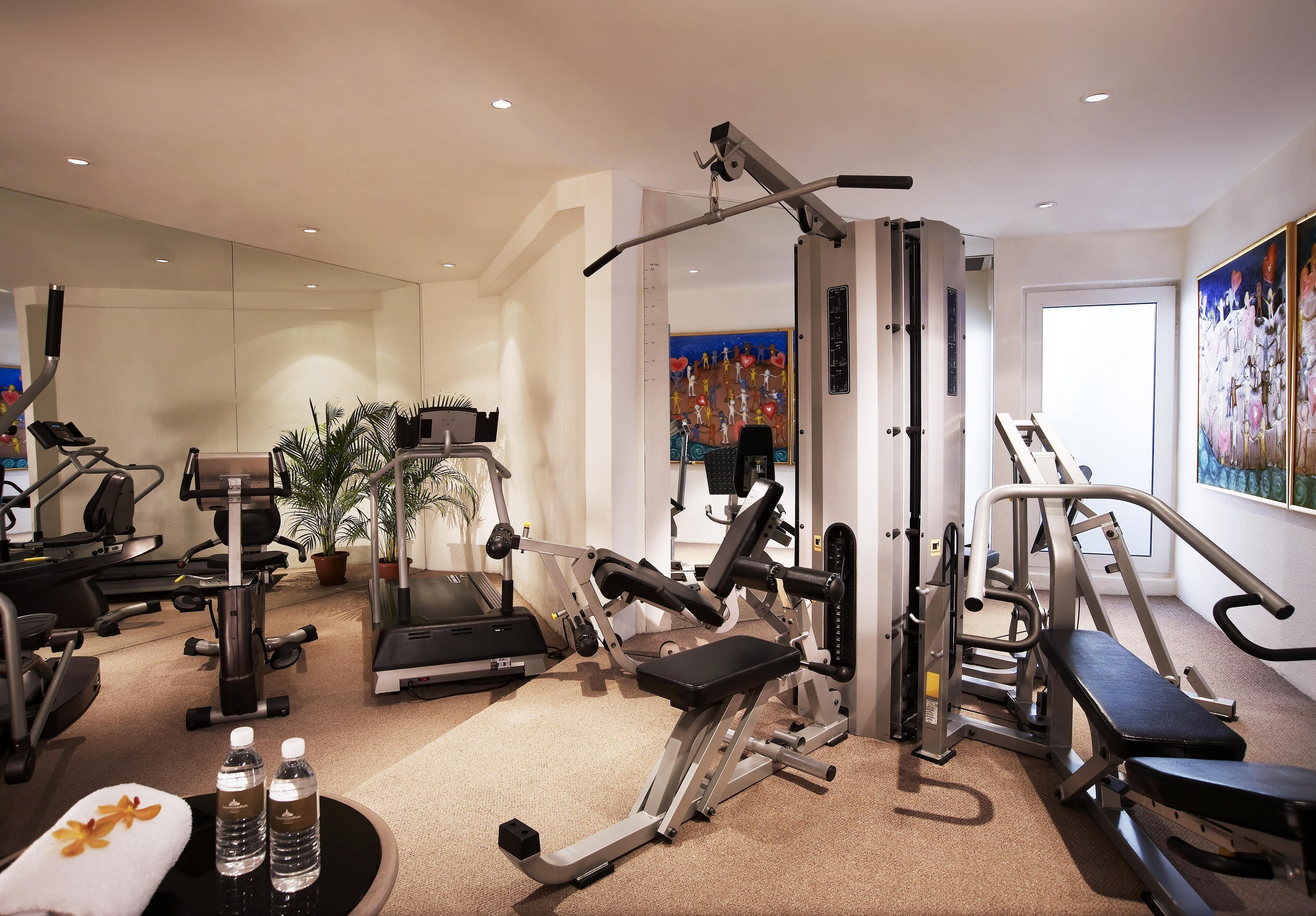 Ein Fitnessstudio mit Trainingsgeräten, Laufband und Wasserspender.