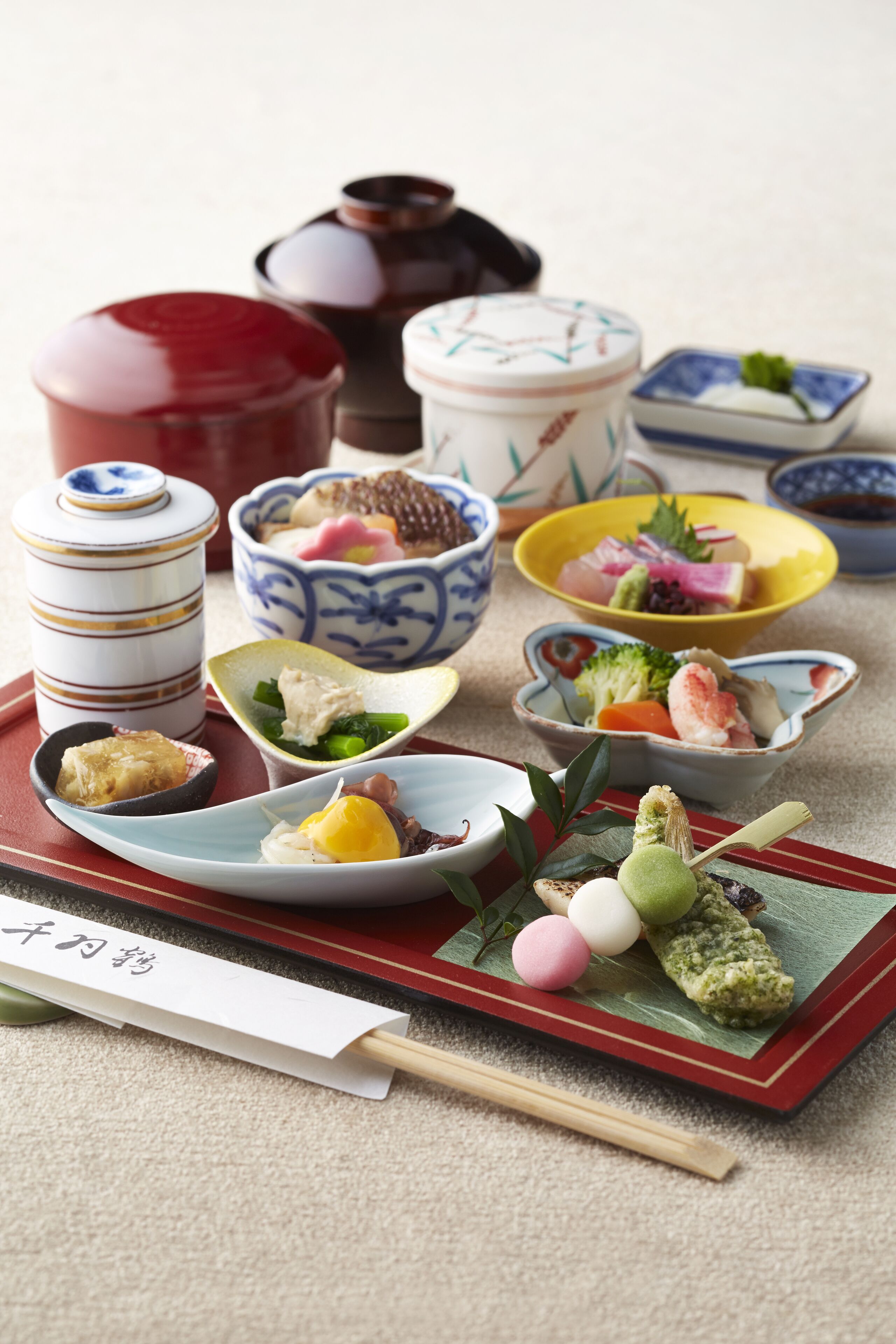 A variety of traditional Japanese dishes arranged on a tray, including sushi, sashimi, and pickled vegetables.