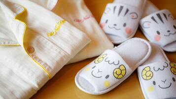 A set of baby items including a blanket and slippers with a cute animal face design.