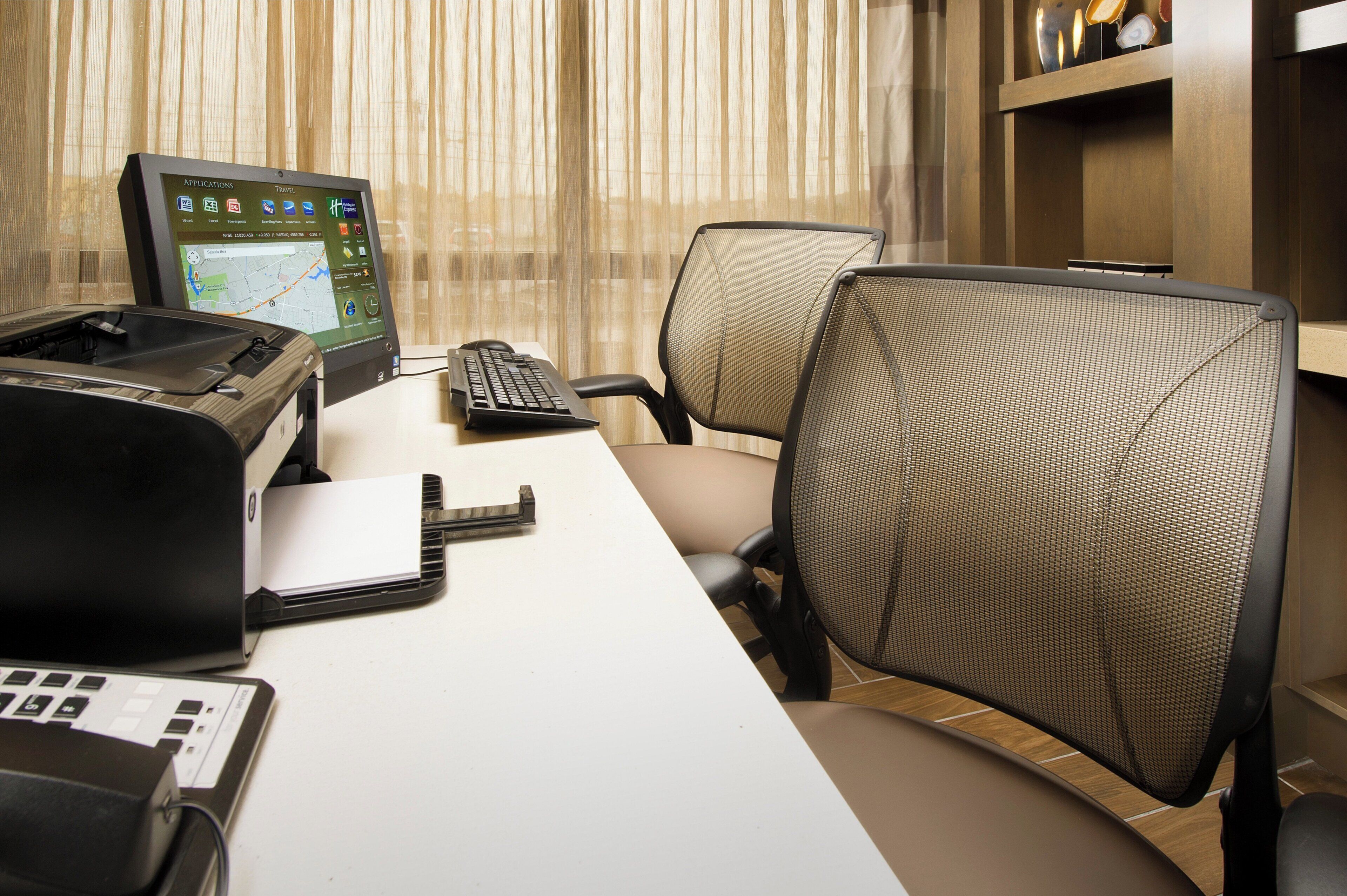 A workspace with a desktop computer, keyboard, mouse, and a printer.