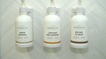 Three bottles of Old Town Woodbury & Co. products: shampoo, conditioner, and body wash, each with a pump dispenser.
