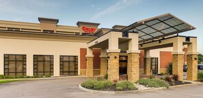 A Drury Inn & Suites building with a modern architectural design, featuring a covered entrance and a landscaped front yard.