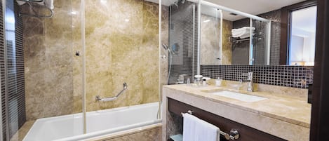 Un baño moderno con ducha acristalada, bañera y tocador con lavabo y espejo.