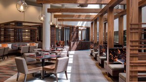 A modern restaurant with wooden beams, seating areas, and pendant lighting. - San Antonio Marriott Northwest Medical Center (San Antonio)