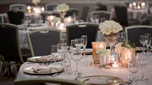A dining table set with plates, cutlery, and glasses, surrounded by chairs. - San Antonio Marriott Northwest Medical Center (San Antonio)