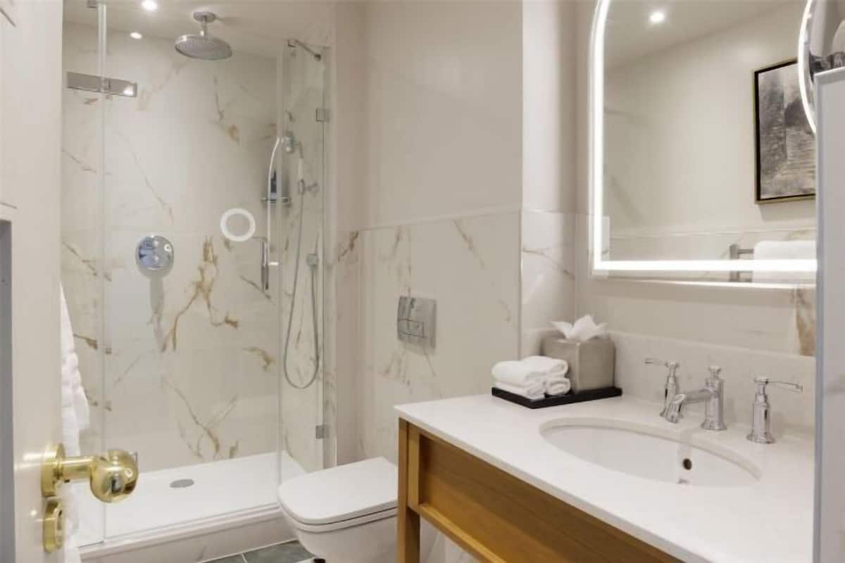 Salle de bain | Douche, articles de toilette griffés, séchoir à cheveux, peignoirs