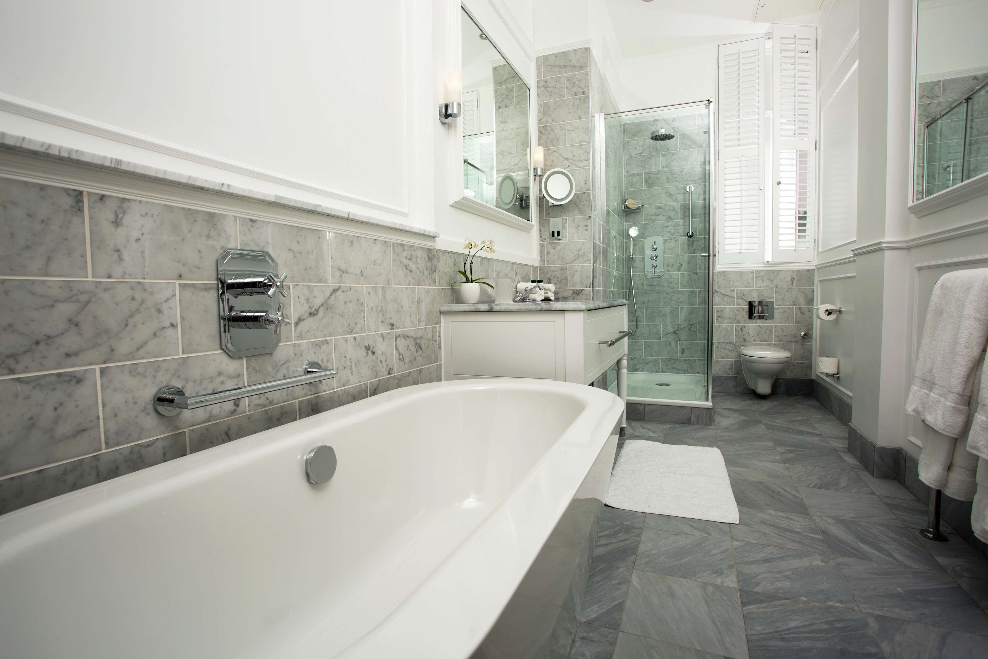 A modern bathroom with a large bathtub, a glass-enclosed shower, and a toilet.