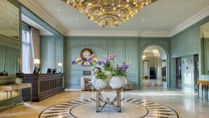 A spacious lobby with a grand chandelier, a reception desk, and a decorative clock. - The Caledonian Edinburgh, Curio Collection by Hilton (Edinburgh)