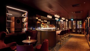A bar area with a long counter, multiple bar stools, and a seating area with round tables and chairs. - The Caledonian Edinburgh, Curio Collection by Hilton (Edinburgh)