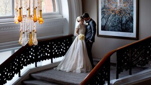 A staircase with a chandelier and a framed picture of trees. - The Caledonian Edinburgh, Curio Collection by Hilton (Edinburgh)