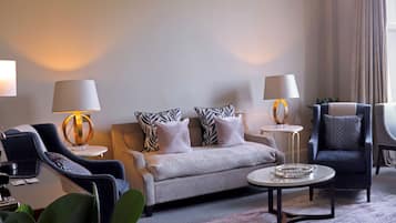 Una sala de estar moderna con un sofá, sillones, una mesa de centro y dos lámparas.