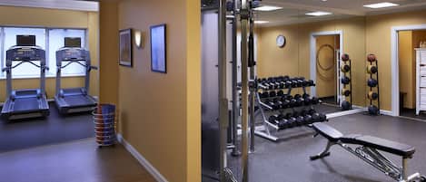 A gym with treadmills, weight machines, and dumbbells.