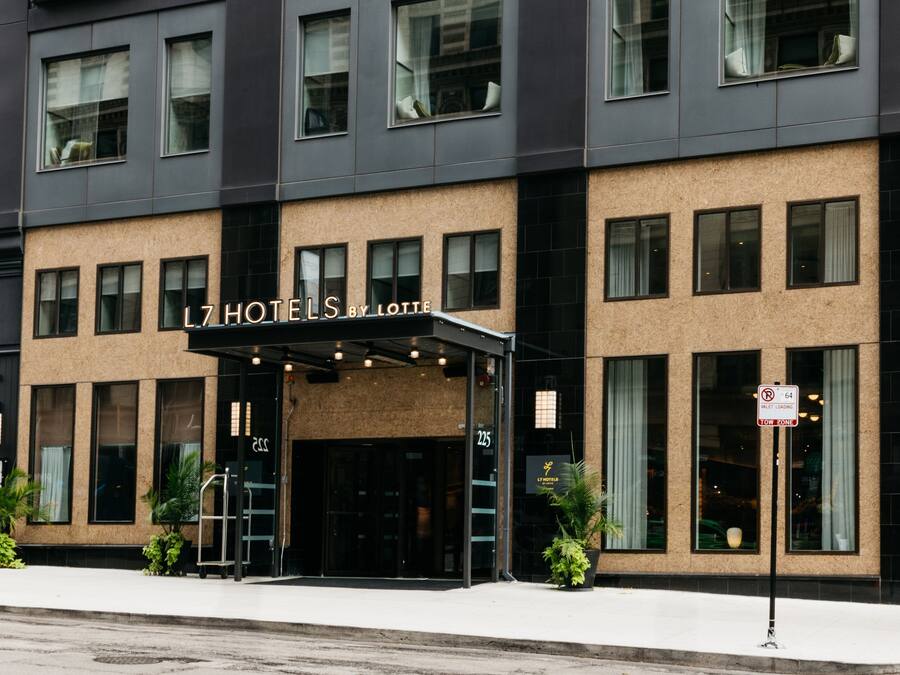 A hotel entrance with a modern facade, large windows, and a sign indicating it is a 64th floor building.