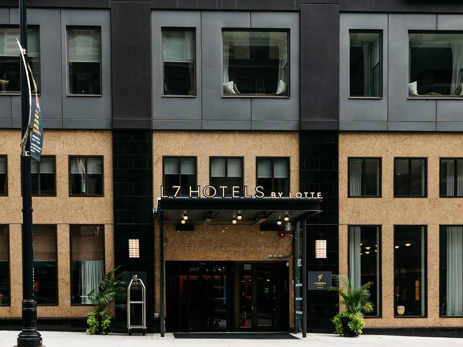 A hotel facade with a sign reading "L7 HOTELS BY LOTTE".