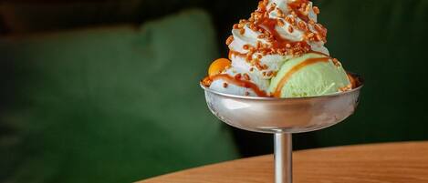 A dessert in a metal bowl on a wooden table.