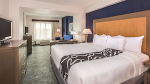 A hotel room with a large bed, a desk with a computer, a TV, and a window with curtains. - La Quinta Inn & Suites by Wyndham Philadelphia Airport (Essington)
