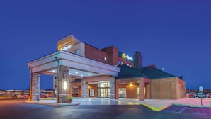 A hotel with a gas station attached, featuring a brick facade and a covered entrance. - La Quinta Inn & Suites by Wyndham Philadelphia Airport (Essington)