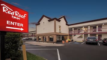 A Red Roof Inn with a sign indicating the entrance direction.