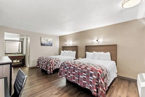Habitació d'hotel amb dos llits, una taula de treball i una cadira.