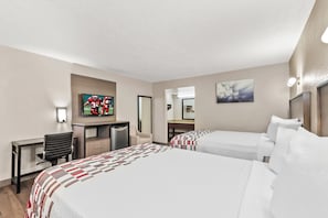 Een hotelkamer met twee bedden, een bureau, een stoel, een televisietoestel en kunst aan de muren.