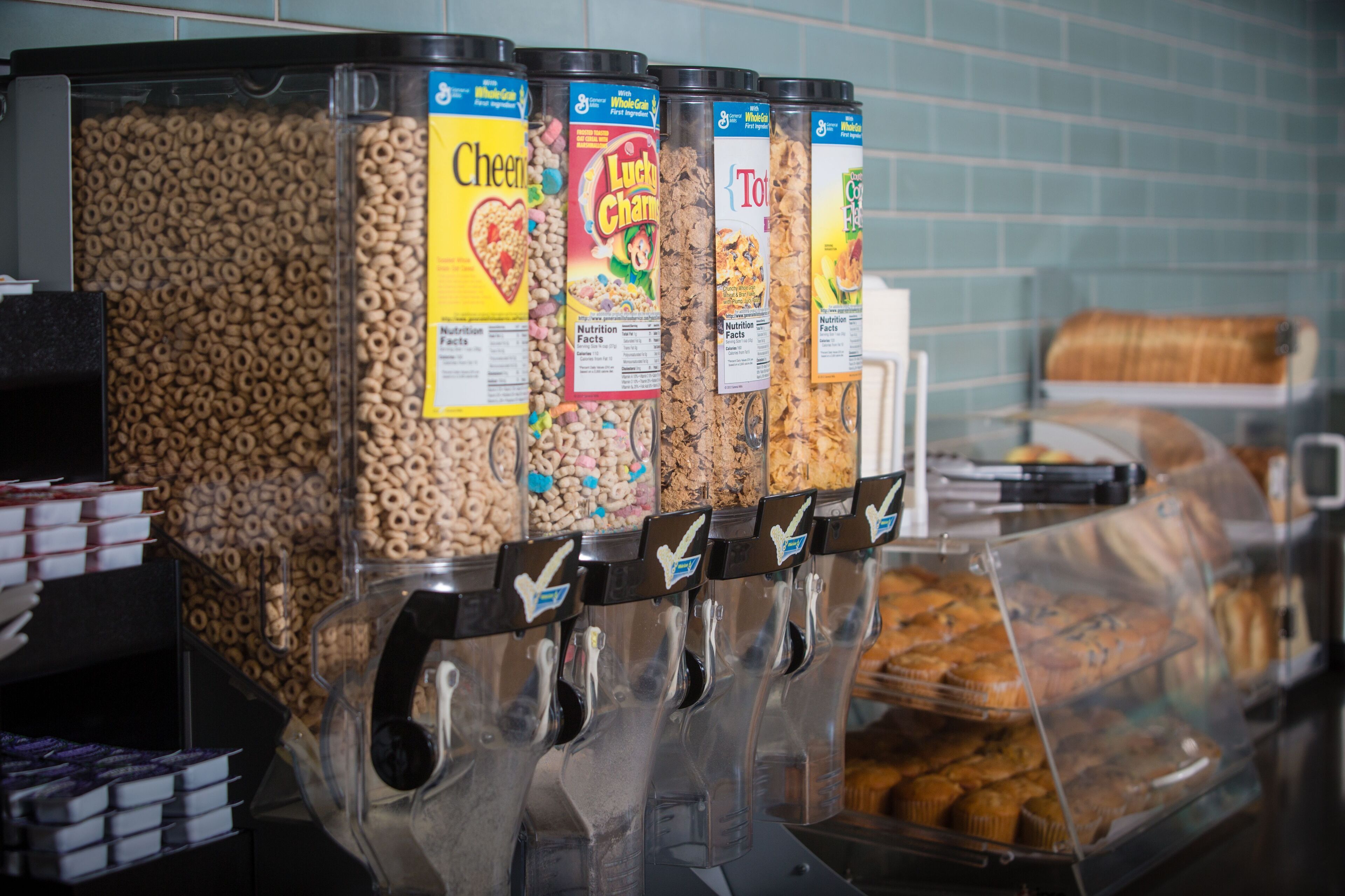 A cereal dispenser with various brands and types of cereal.